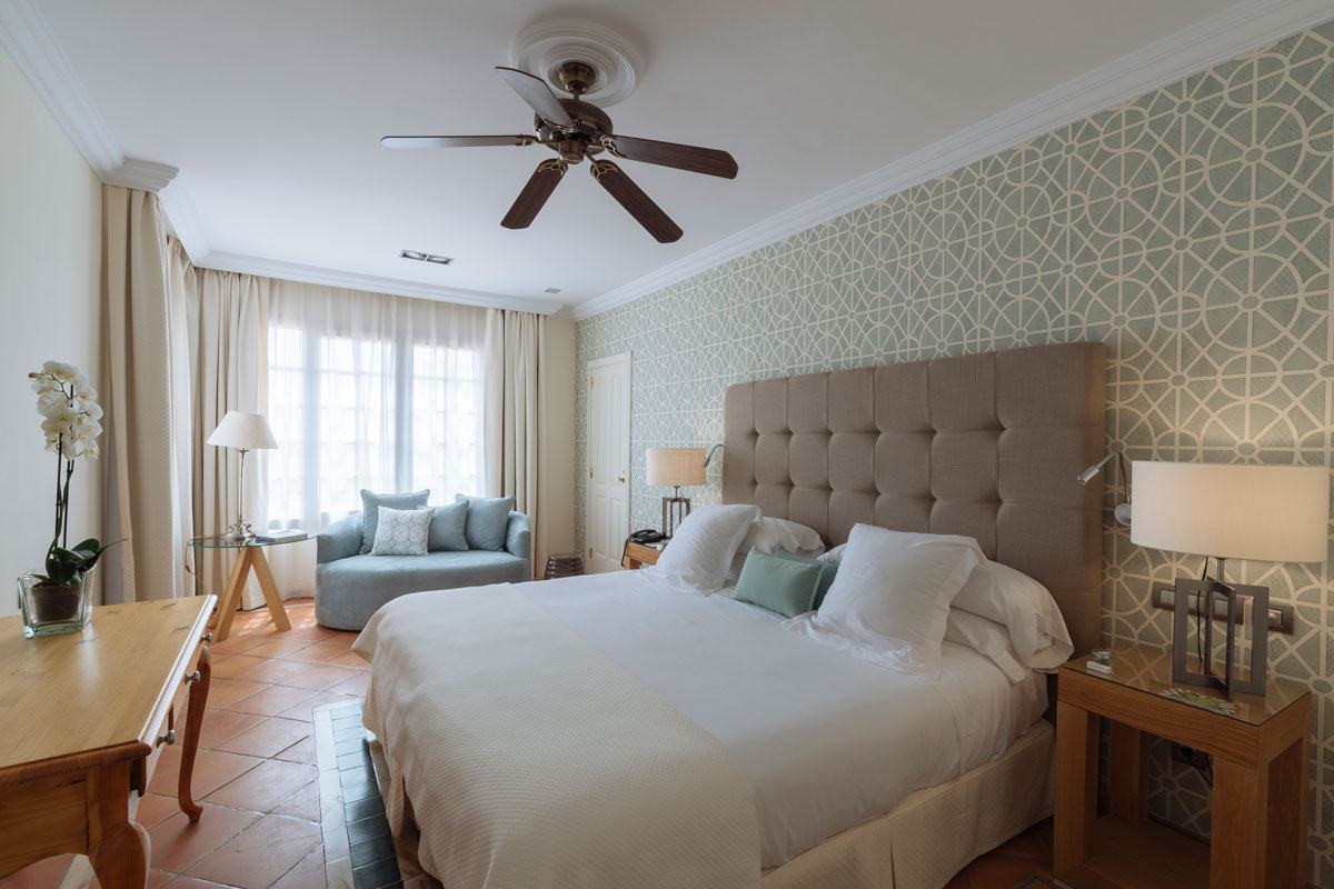Habitación luminosa con cama doble y sofá en hotel de Tenerife.