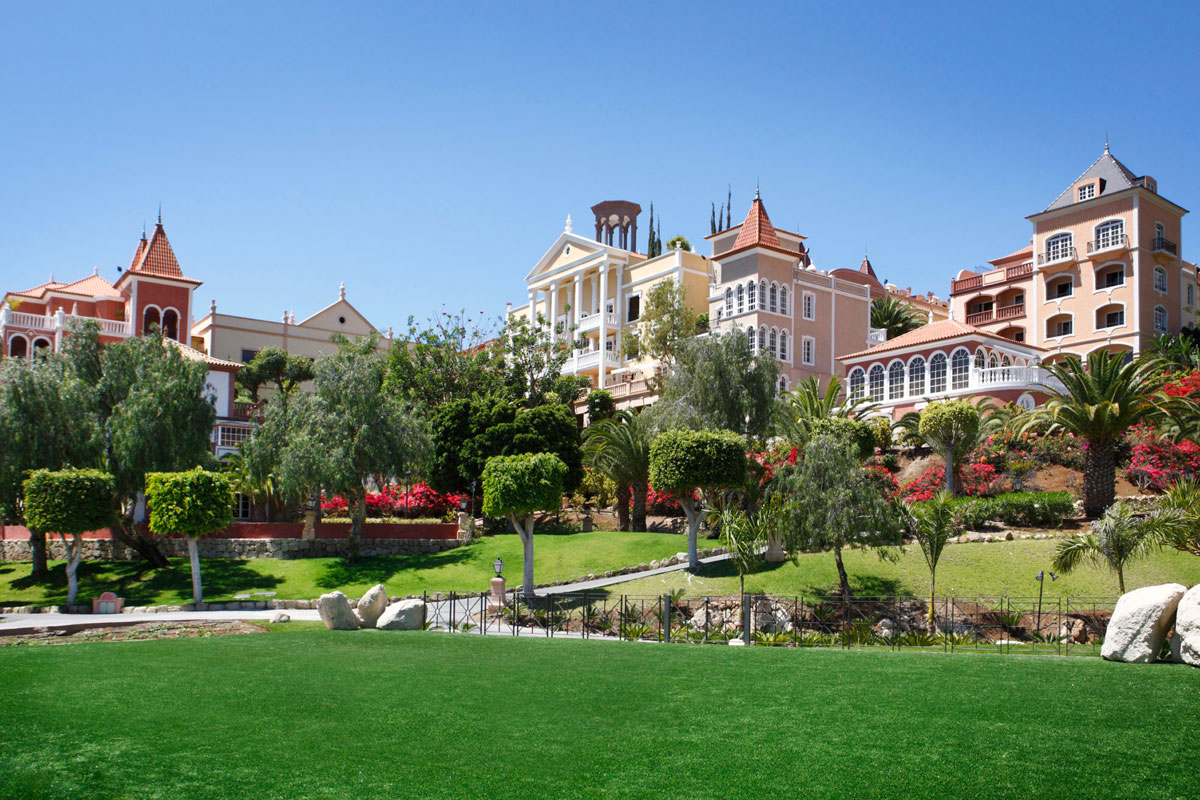 Edificios coloridos rodeados de jardines y palmeras en Tenerife.