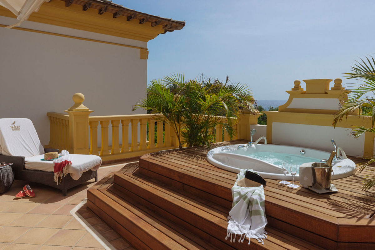 Terraza con jacuzzi, tumbona y vista al mar en hotel de Tenerife.