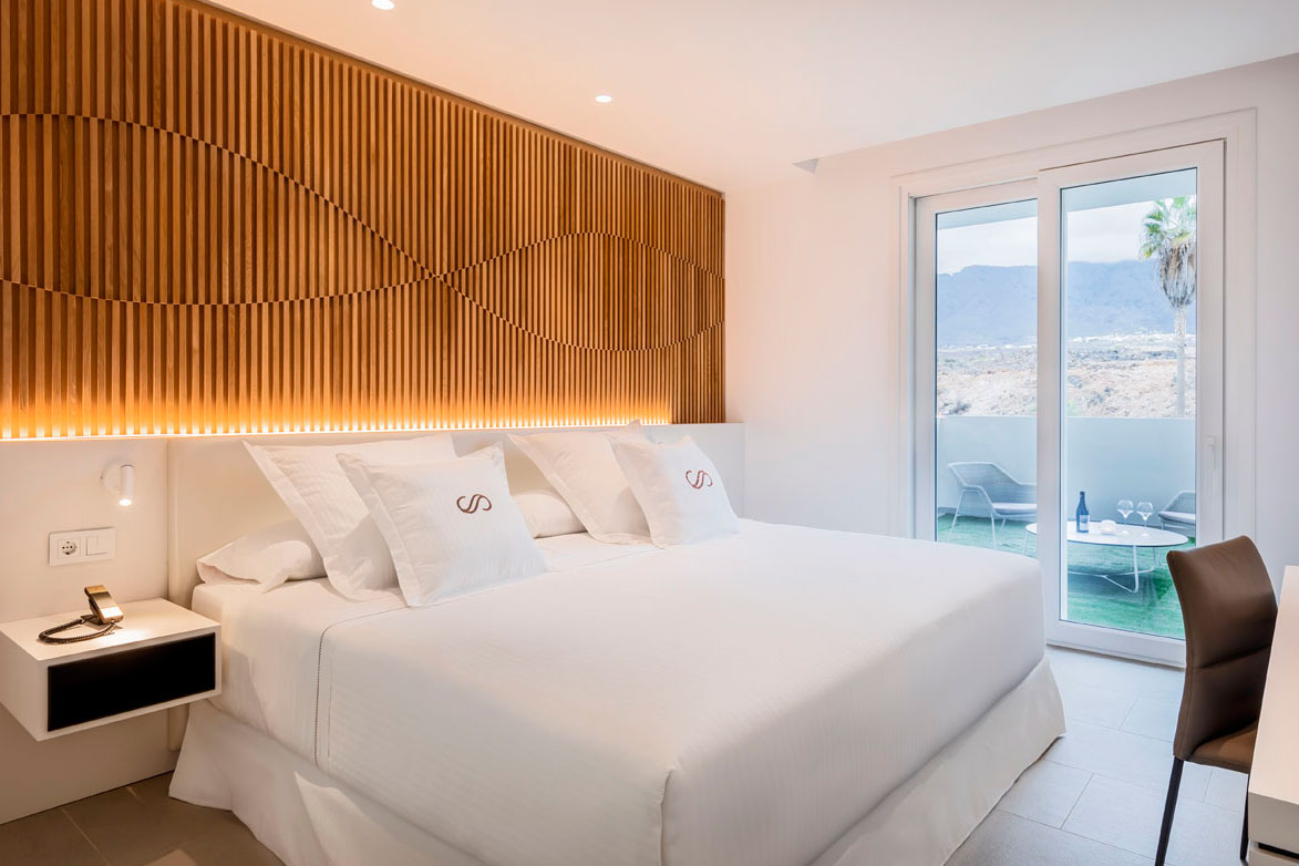 Habitación de hotel en Tenerife con cama doble, terraza y vista al exterior.