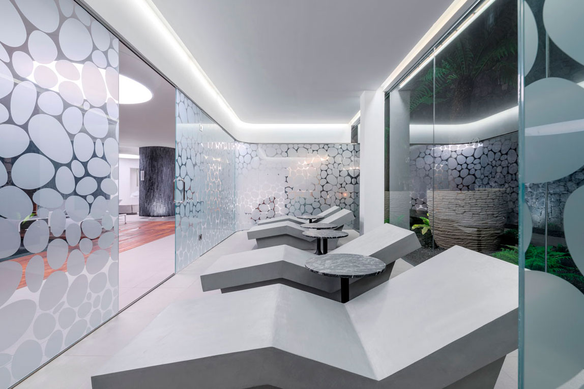 Sala de relajación con tumbonas y paredes de vidrio con diseño de círculos en Tenerife.
