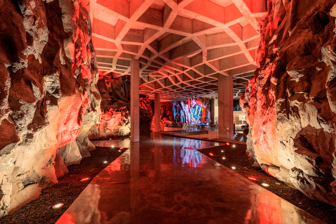 Pasillo con estructura en techo y paredes de roca iluminadas en rojo en Tenerife.