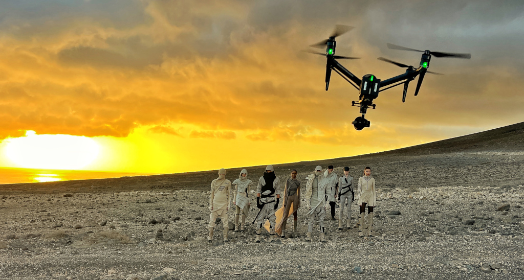 Grupo con trajes futuristas y un dron volando sobre un paisaje desértico en Tenerife.
