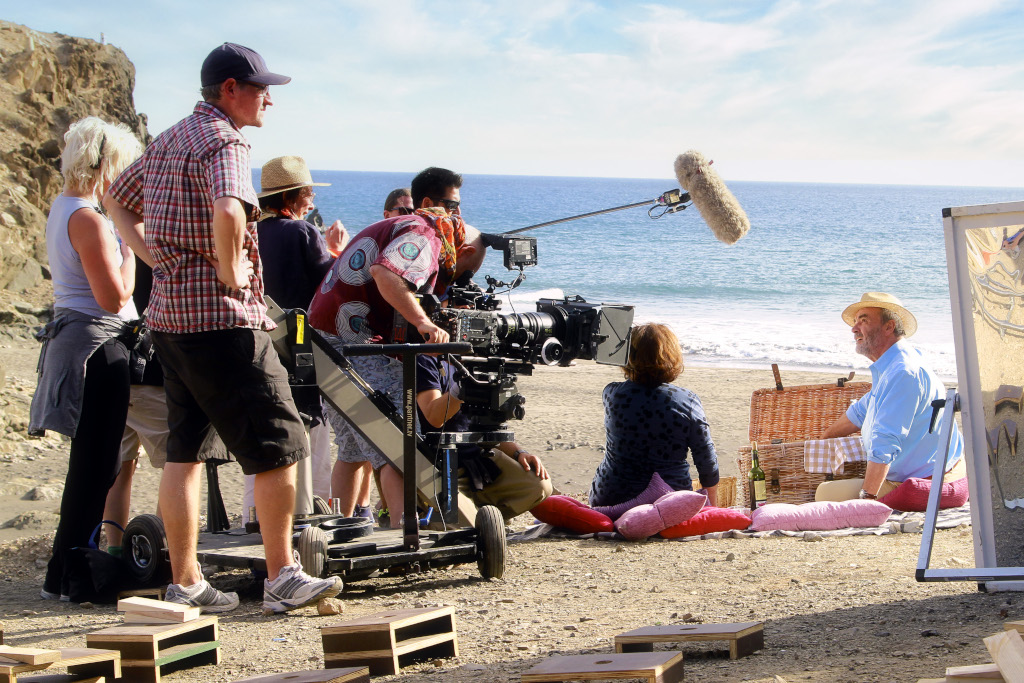 Equipo de filmación en una playa de Tenerife grabando una escena con actores y picnic.