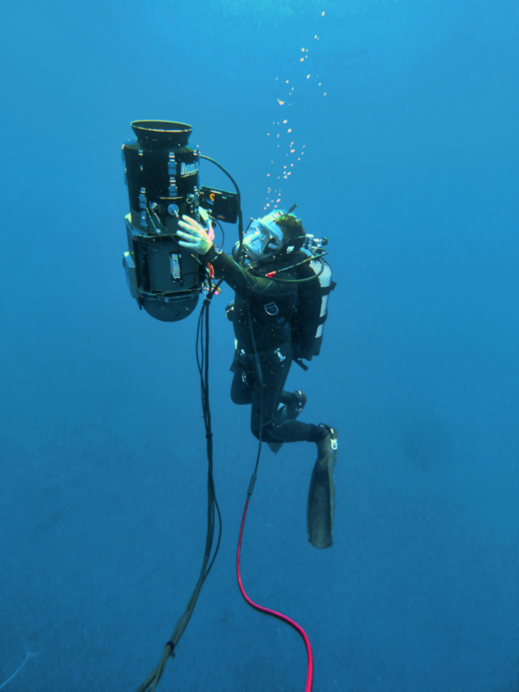 Buceador manejando equipo de investigación submarina en Tenerife.