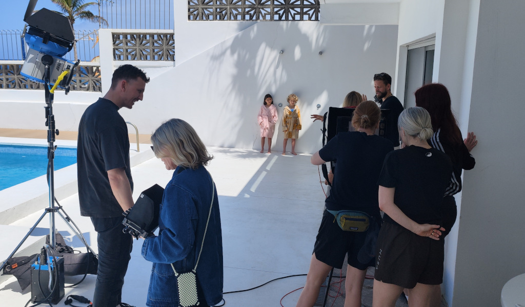 Equipo de filmación grabando a dos niños en una terraza junto a una piscina en Tenerife.
