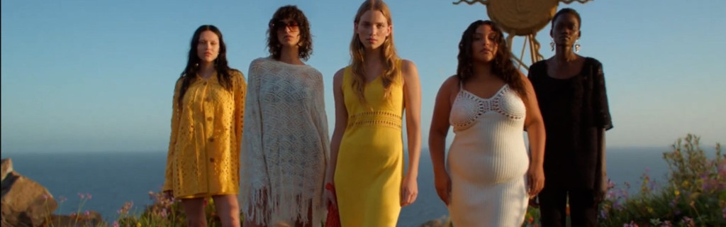 Cinco personas con vestidos coloridos de pie frente al mar en Tenerife.