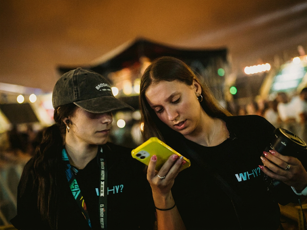 Una persona fotografía un traje luminoso con luces LED en un evento nocturno en Tenerife.