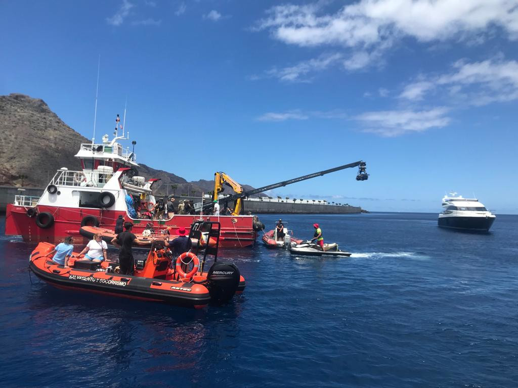 Barcos en el puerto de Tenerife con un bote de rescate y equipo de filmación.