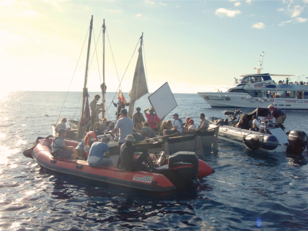 Personas en embarcaciones inflables y velero en el mar cerca de Tenerife.
