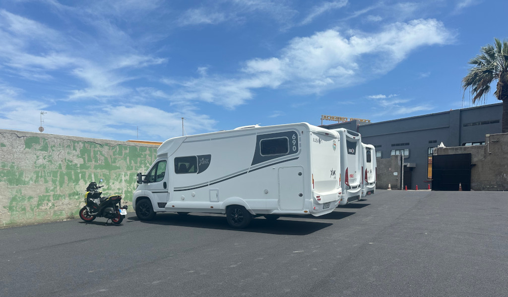 Autocaravanas y una moto estacionadas en un aparcamiento de Tenerife.