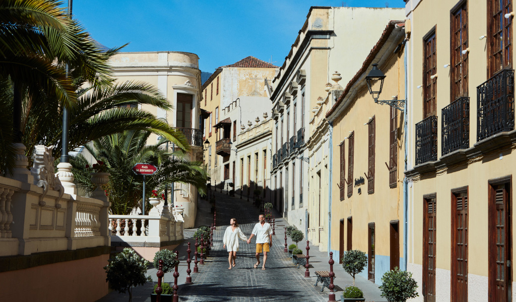 Pareja caminando por una calle con edificios históricos en La Orotava, Tenerife.
