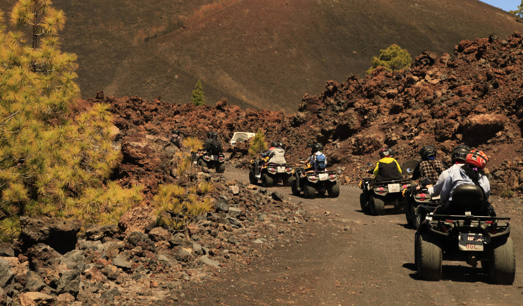 Grupo en quads recorriendo un camino volcánico en Tenerife.