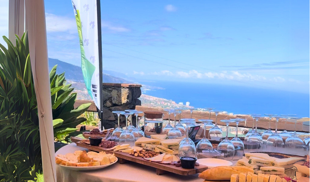 Mesa con bandejas de quesos y copas frente a vista panorámica en Tenerife.