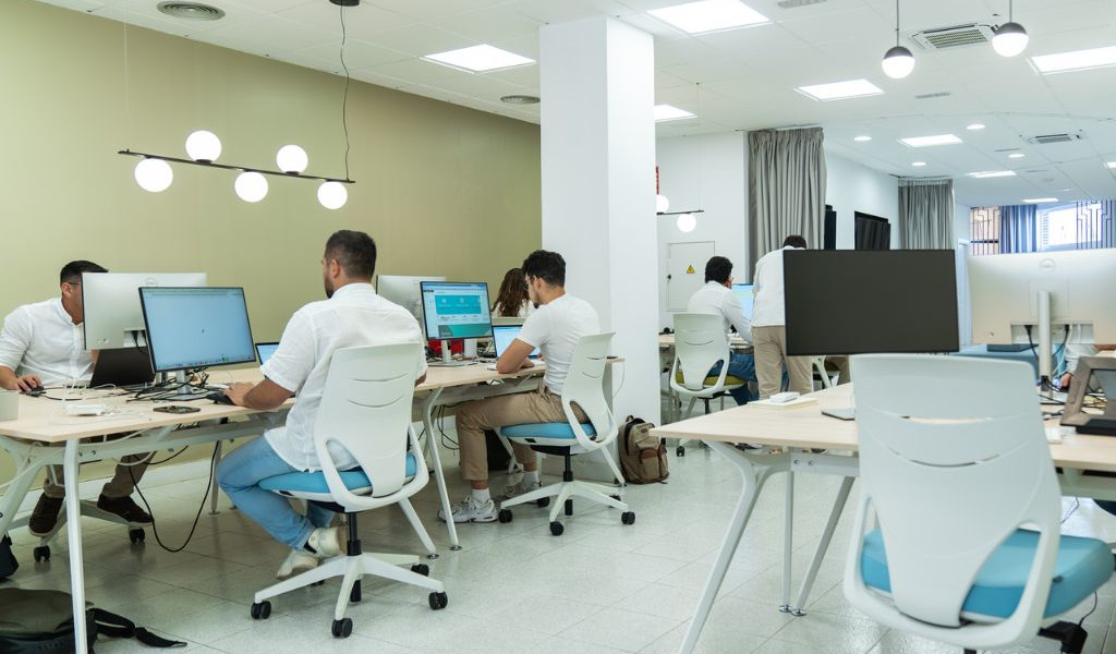 Personas trabajando en oficina con computadoras en Tenerife.