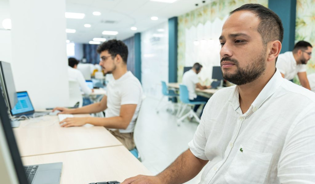 Personas trabajando en computadoras en una oficina moderna en Tenerife.