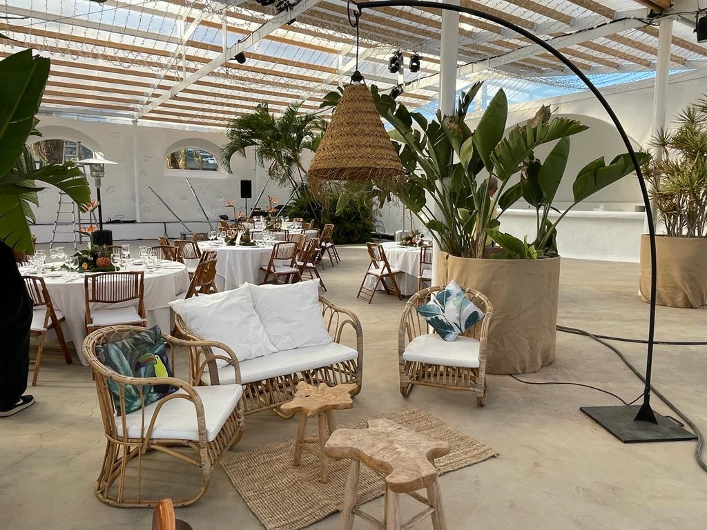 Espacio al aire libre con muebles de mimbre y mesas decoradas en Tenerife.
