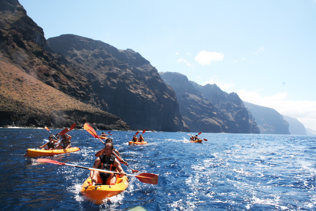 Personas en kayak frente a acantilados en Los Gigantes, Tenerife.