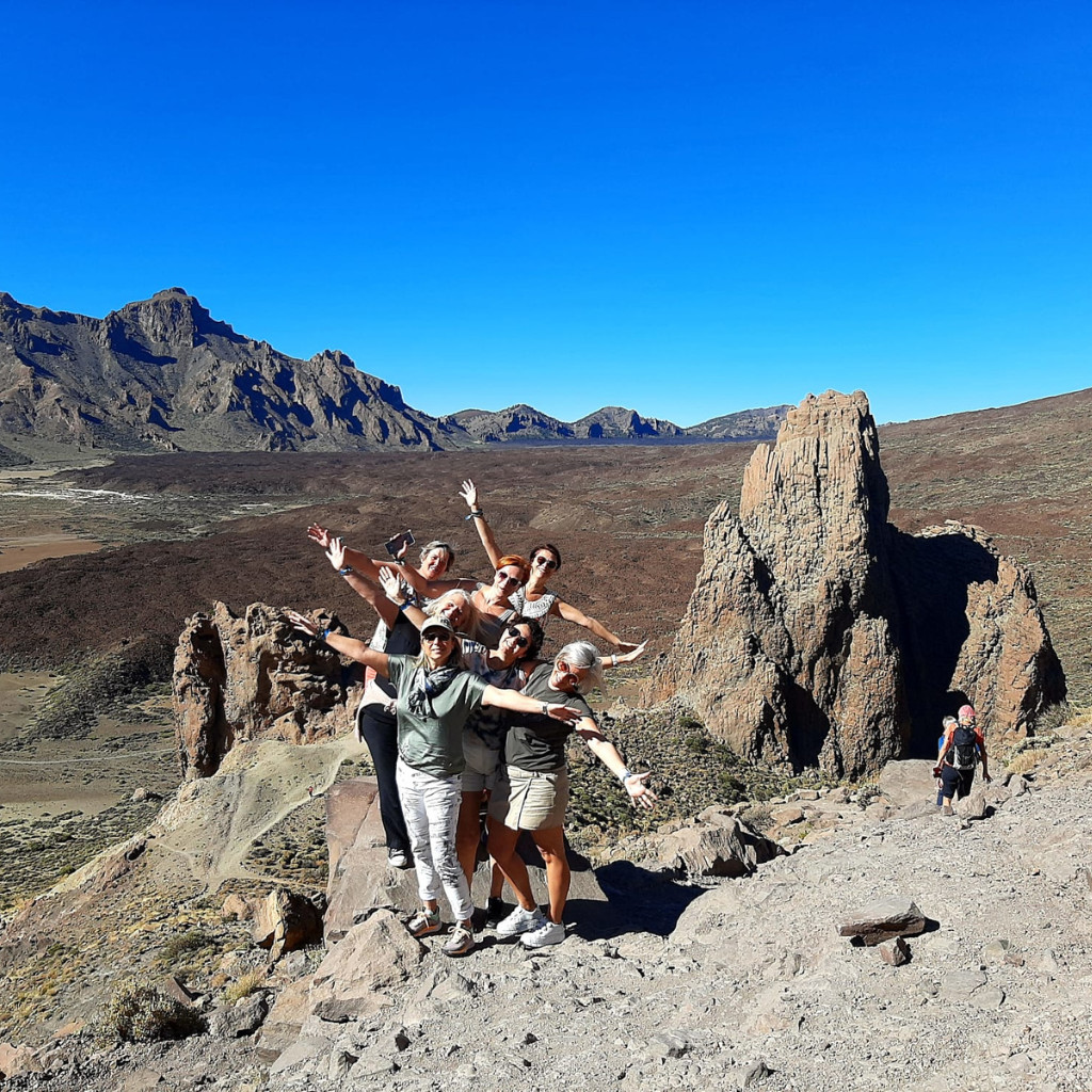 Grupo de personas posando frente a paisaje rocoso del Teide en Tenerife.