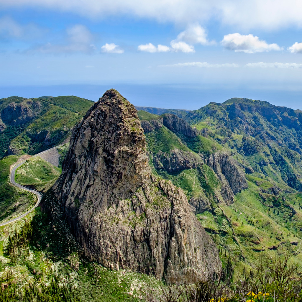 Montañas verdes y roca en Tenerife bajo un cielo azul.