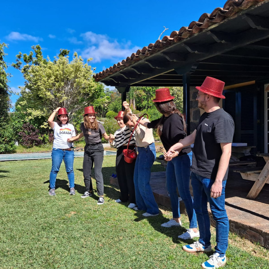 Grupo de personas con sombreros rojos en el jardín de una casa en Tenerife.