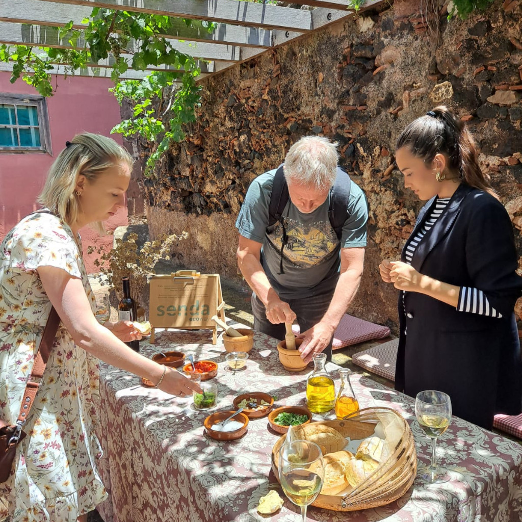 Personas preparando comida en una mesa al aire libre en La Laguna, Tenerife.