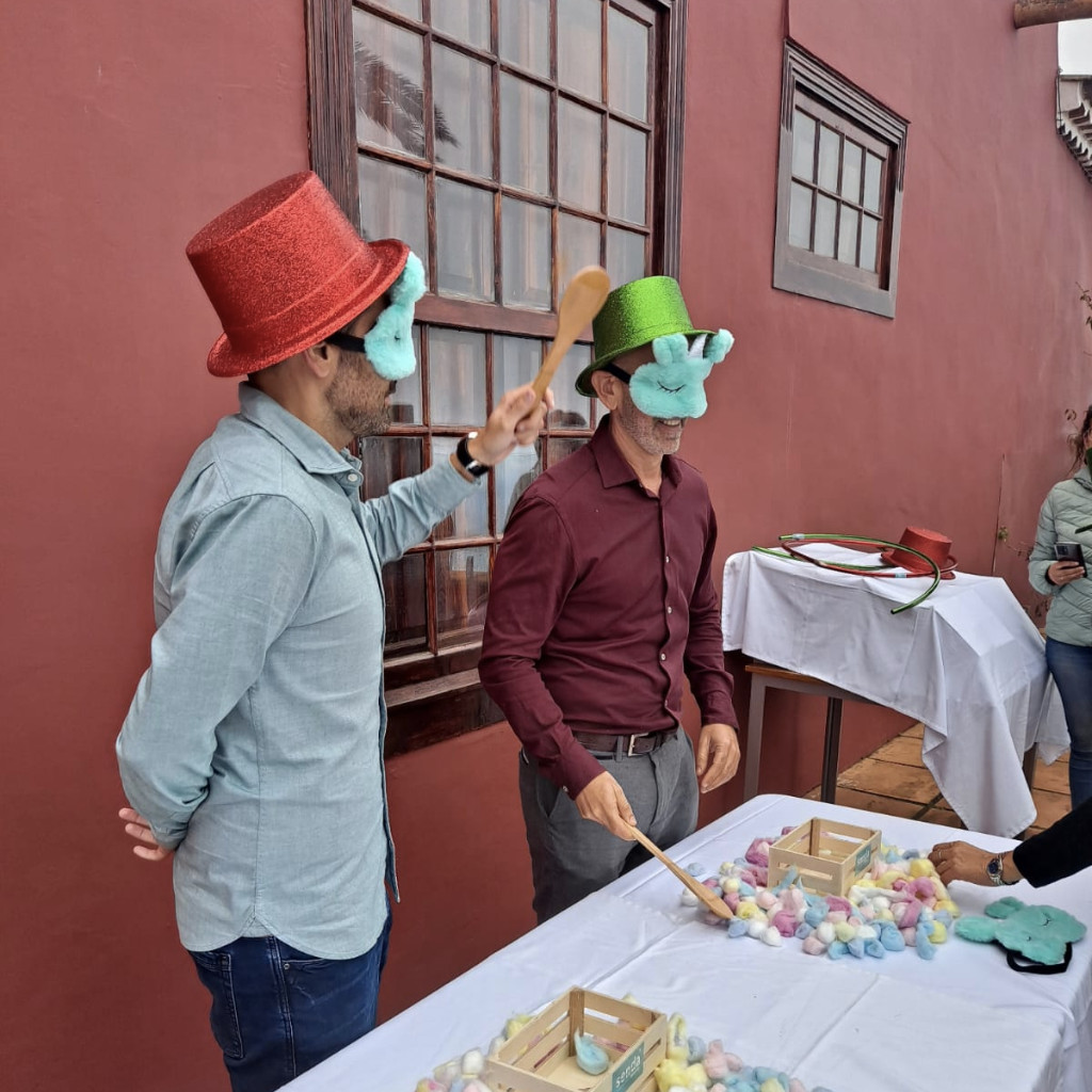 Personas con sombreros en juego con cucharas y objetos coloridos en Tenerife.