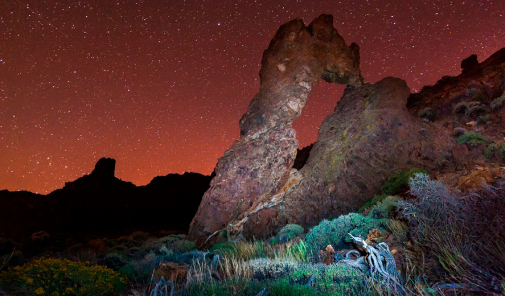 Roca en forma de arco bajo un cielo estrellado en el Parque Nacional del Teide, Tenerife.