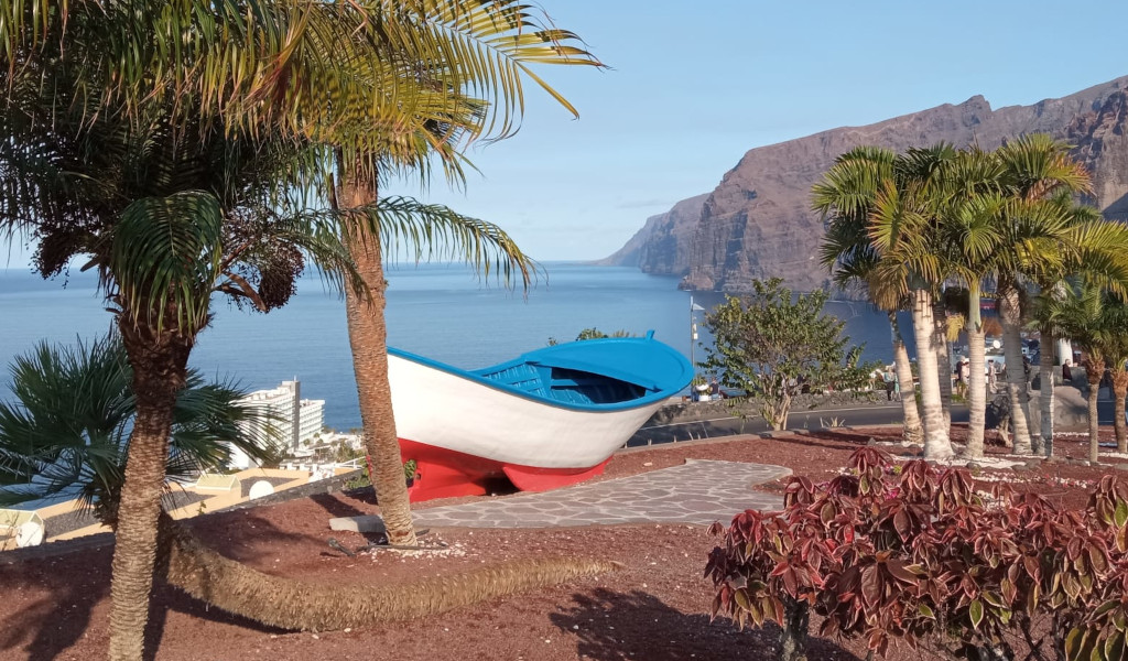 Bote azul y blanco en un parque con vistas a Los Gigantes, Tenerife.