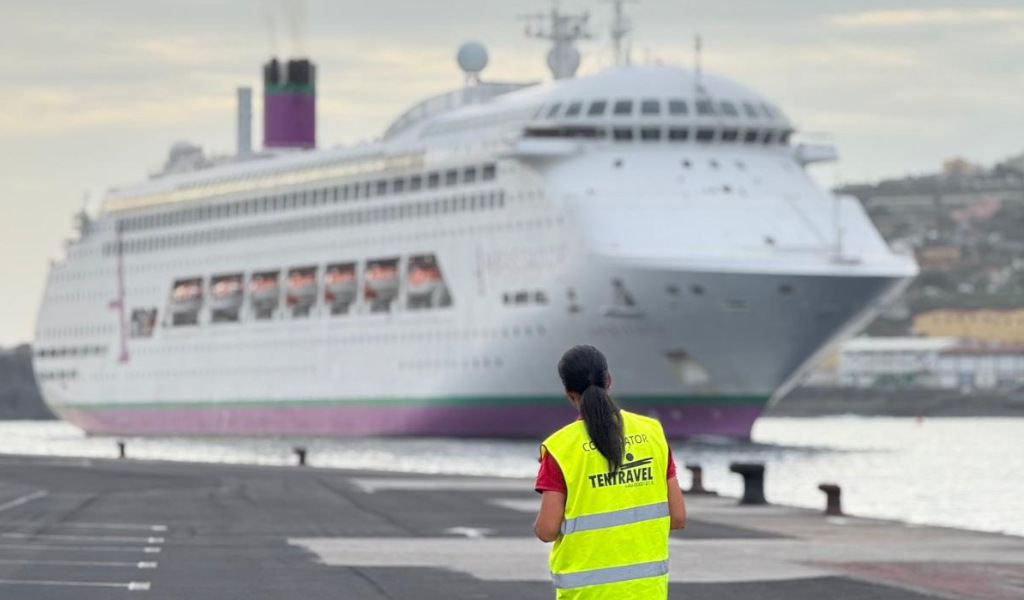 Persona observando un crucero atracado en el puerto de Tenerife. Chaleco dice Coordinator Tentravel.