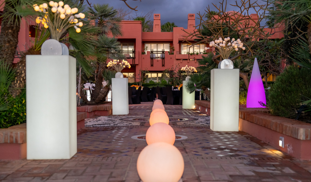 Entrada iluminada al atardecer con plantas y luces en un hotel en Tenerife.
