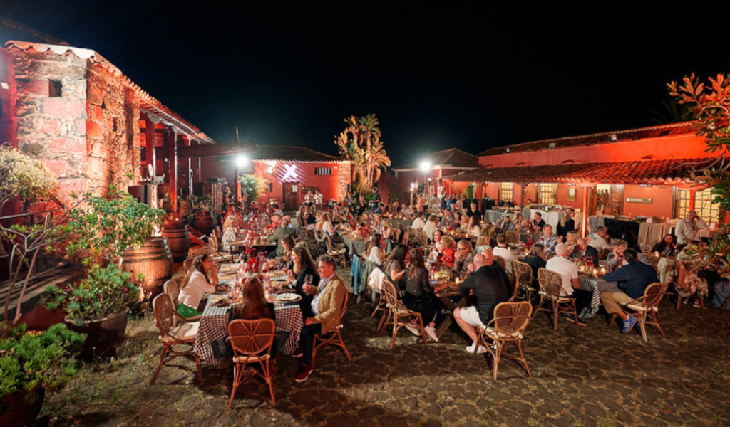 Gente cenando al aire libre en una finca en Tenerife durante la noche.