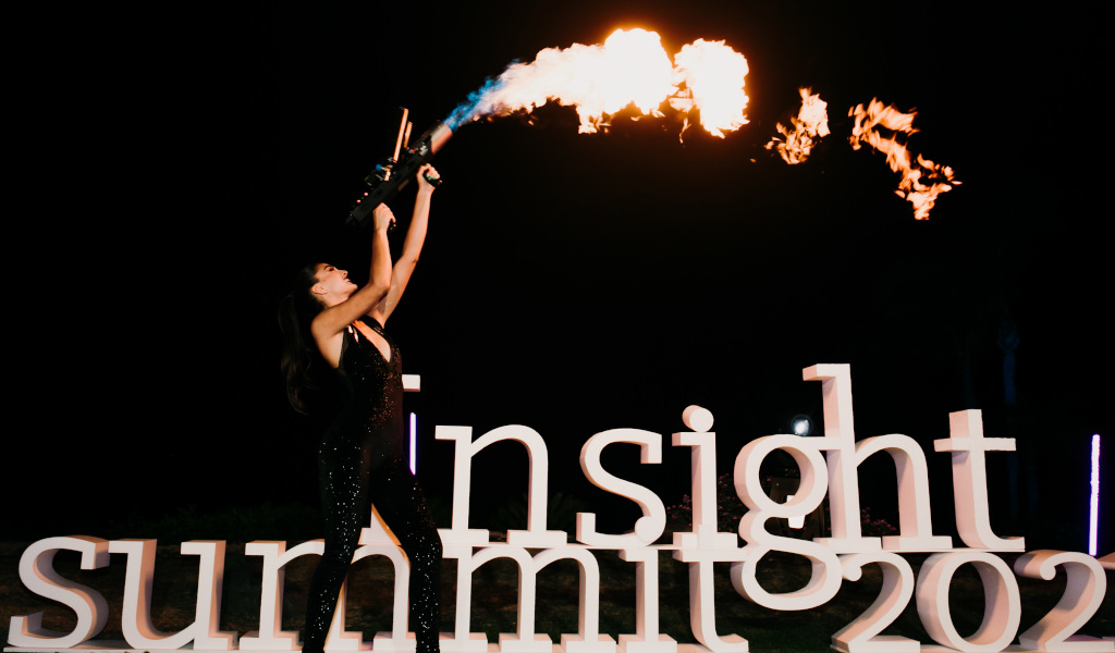 Persona lanzallamas junto a letras insight summit 2021 en evento nocturno en Tenerife.