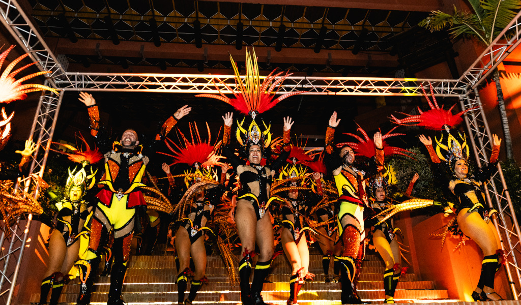 Personas bailando en el carnaval de Tenerife con trajes coloridos.