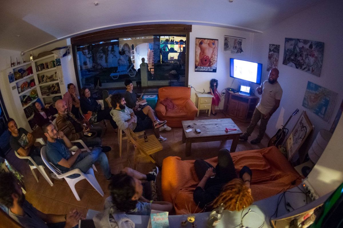 Grupo de personas asistiendo a una presentación en una sala de estar en Tenerife.