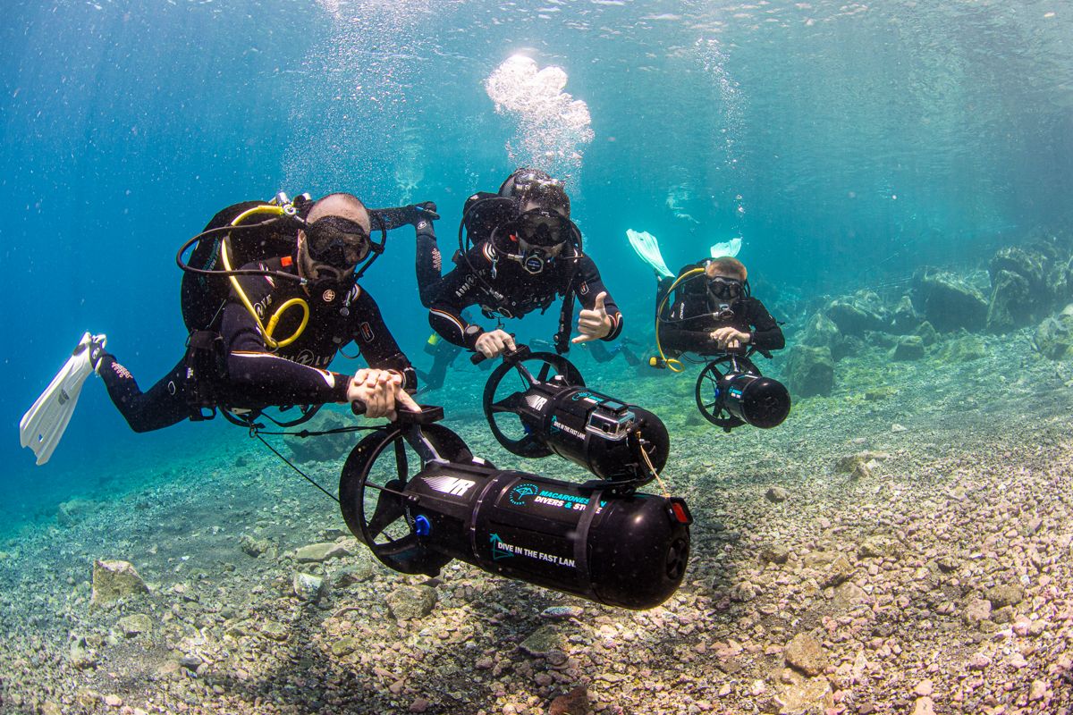 Buzos con propulsores submarinos explorando aguas cristalinas en Tenerife.