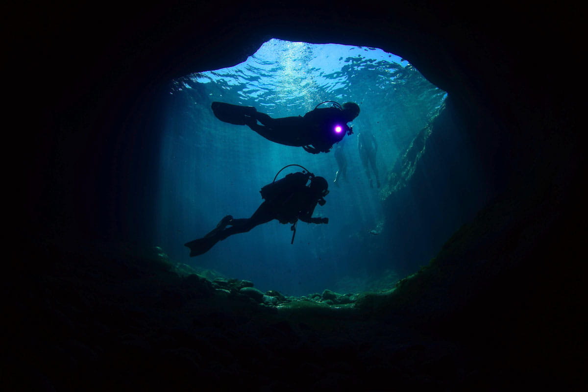 Buceadores explorando una cueva submarina en Tenerife.