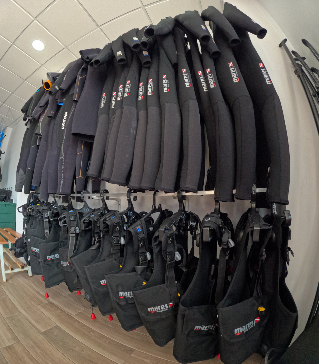 Trajes de buceo y chalecos colgados en un centro de buceo en Tenerife.