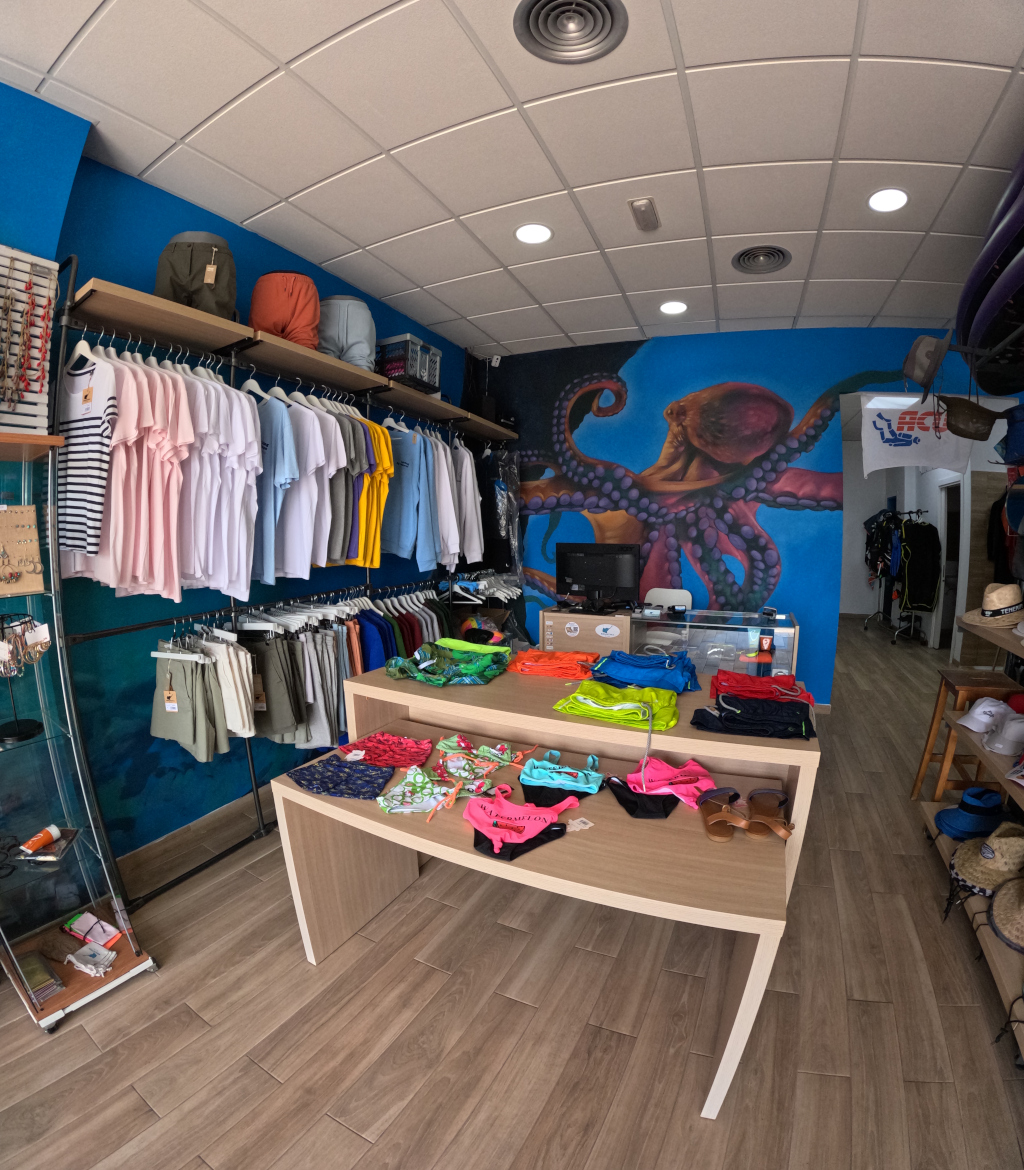 Tienda de ropa con camisetas y pantalones en exhibición en Tenerife.