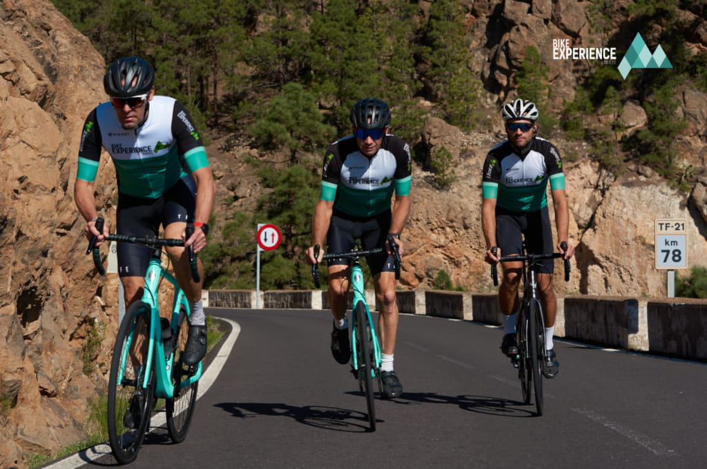 Ciclistas en carretera TF-21 km 78, Tenerife. Señal de tráfico visible.