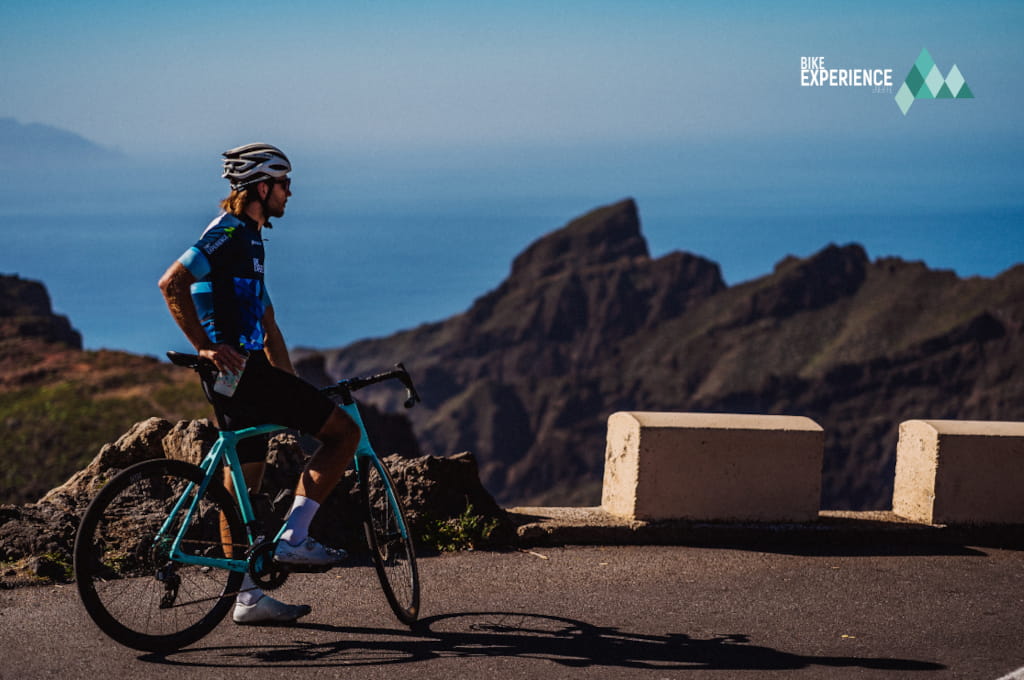 Ciclista en carretera montañosa de Tenerife con vistas al mar.