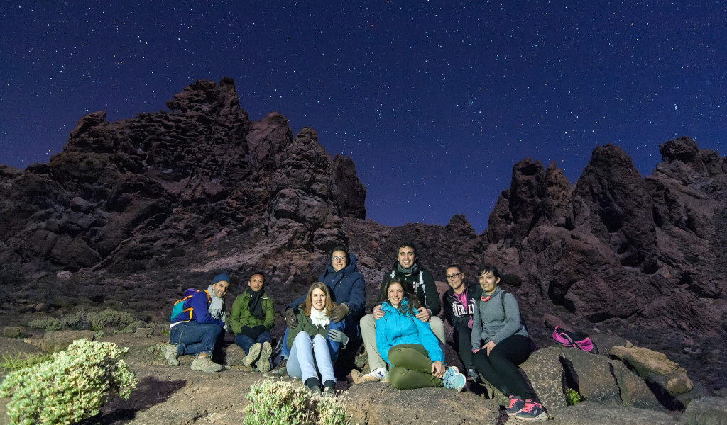 Grupo de personas bajo estrellas en el Parque Nacional del Teide, Tenerife.