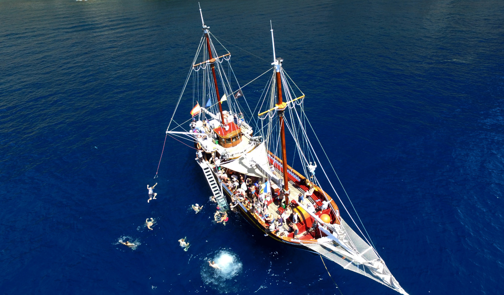 Barco turístico con personas nadando cerca de Tenerife.