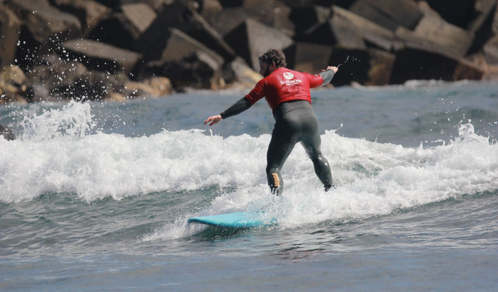Persona surfeando una ola pequeña en el mar de Tenerife.