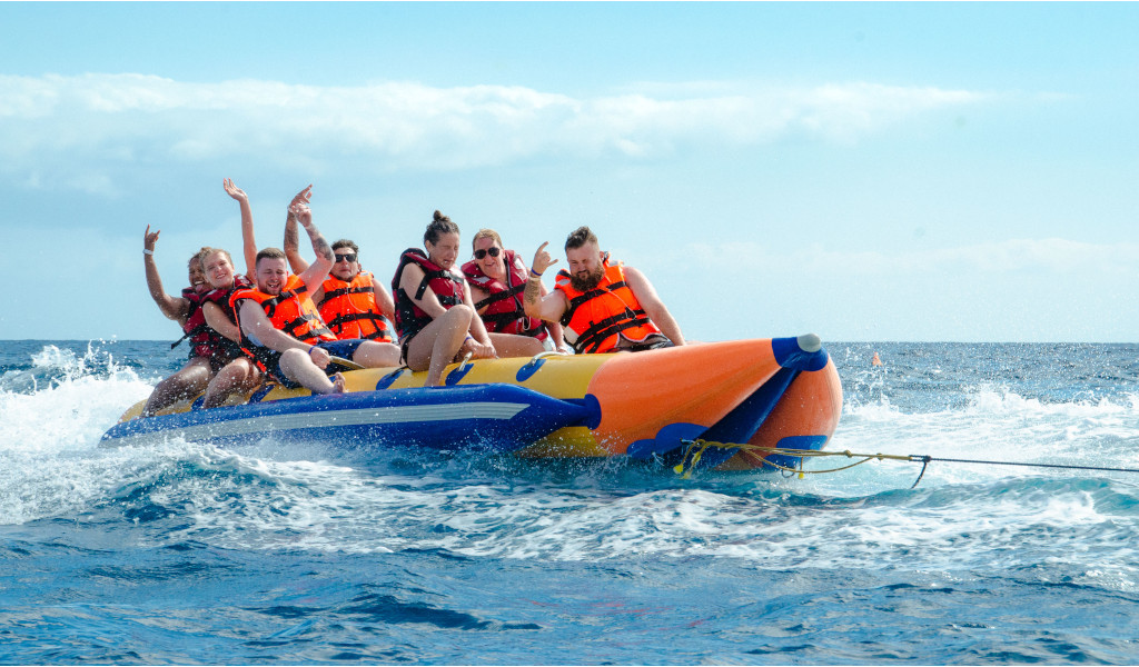 Personas en una banana inflable sobre el mar en una actividad acuática en Tenerife.