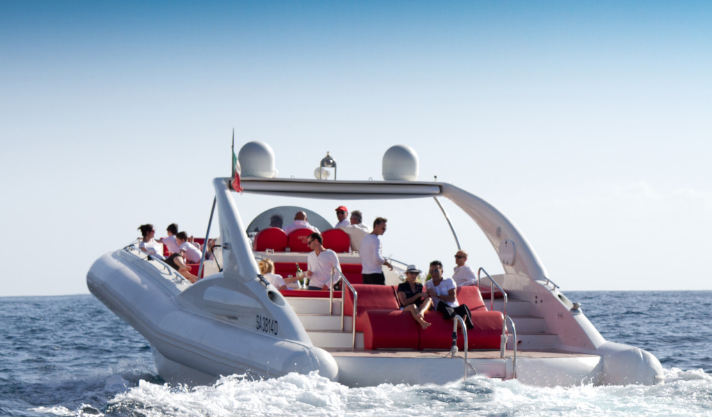 Personas disfrutando de un paseo en un barco con asientos rojos en el mar cerca de Tenerife.
