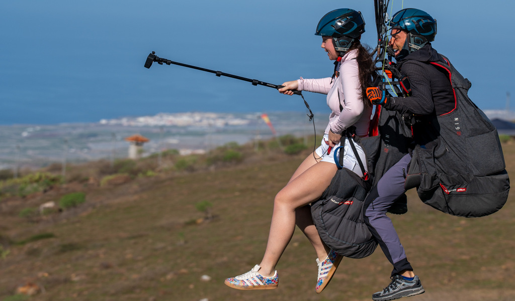 Dos personas practicando parapente sobre un paisaje de Tenerife.