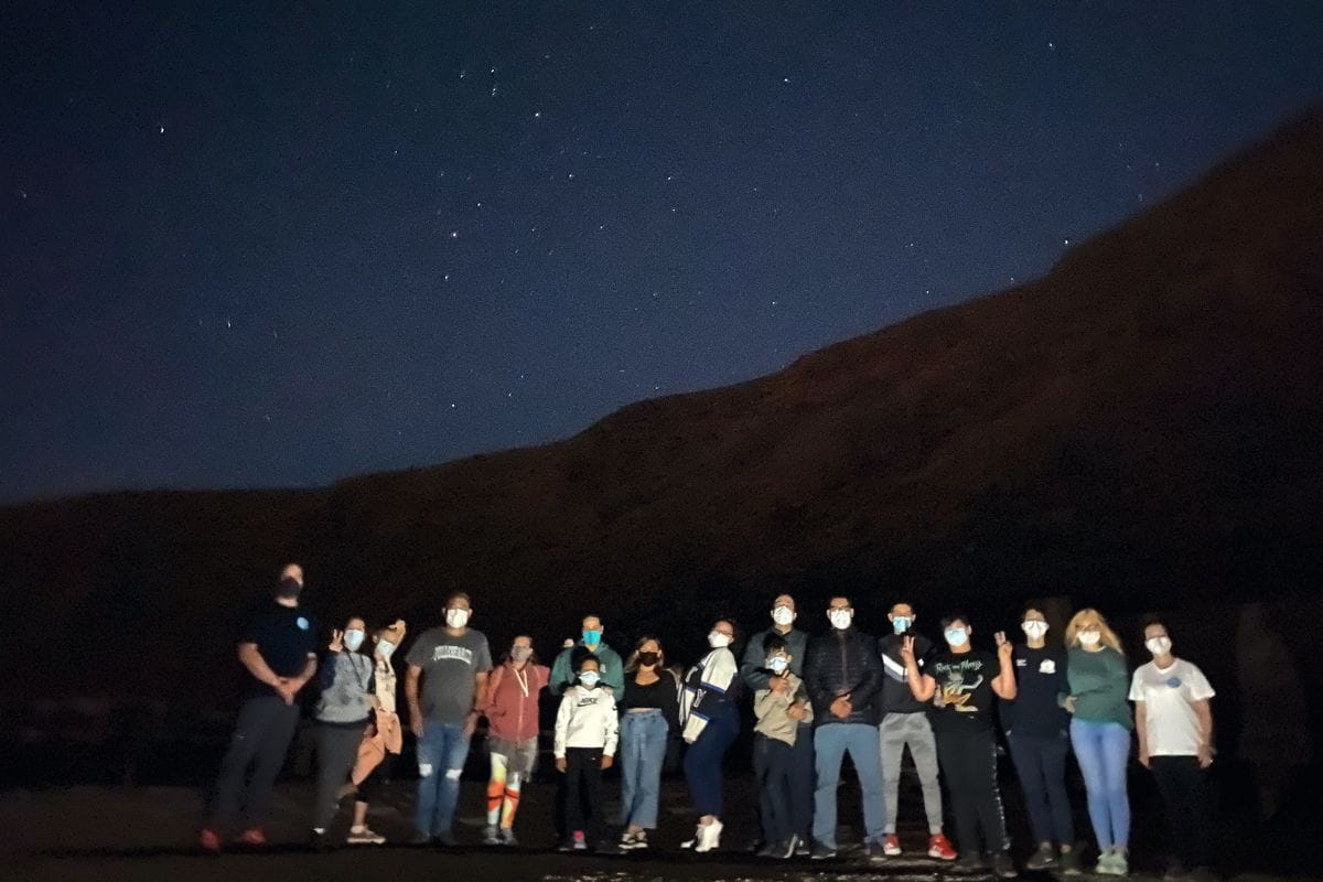 Grupo observando estrellas bajo el cielo nocturno en Tenerife.
