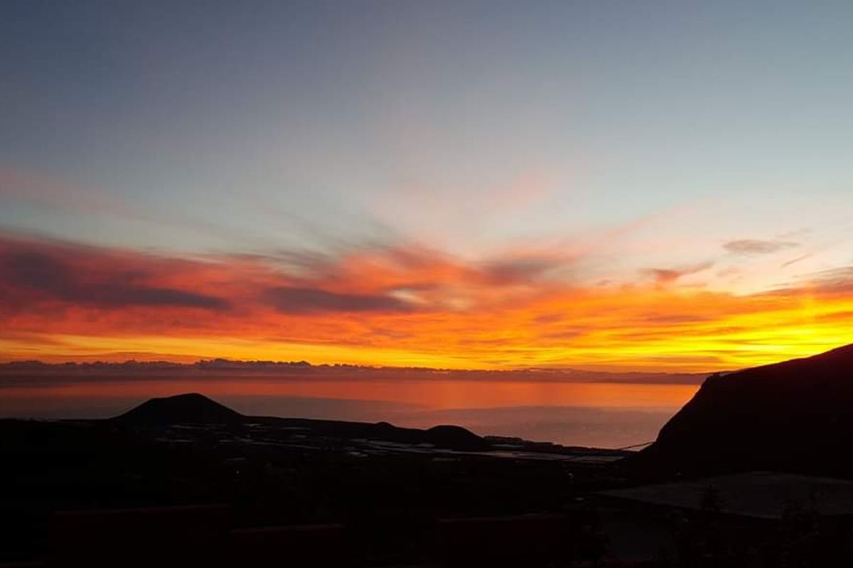 Atardecer con cielo naranja y montañas en Tenerife.