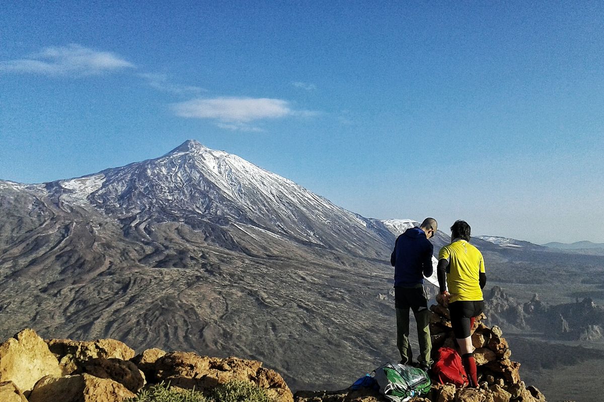 Dos personas de pie en un mirador con vista al volcán Teide en Tenerife.